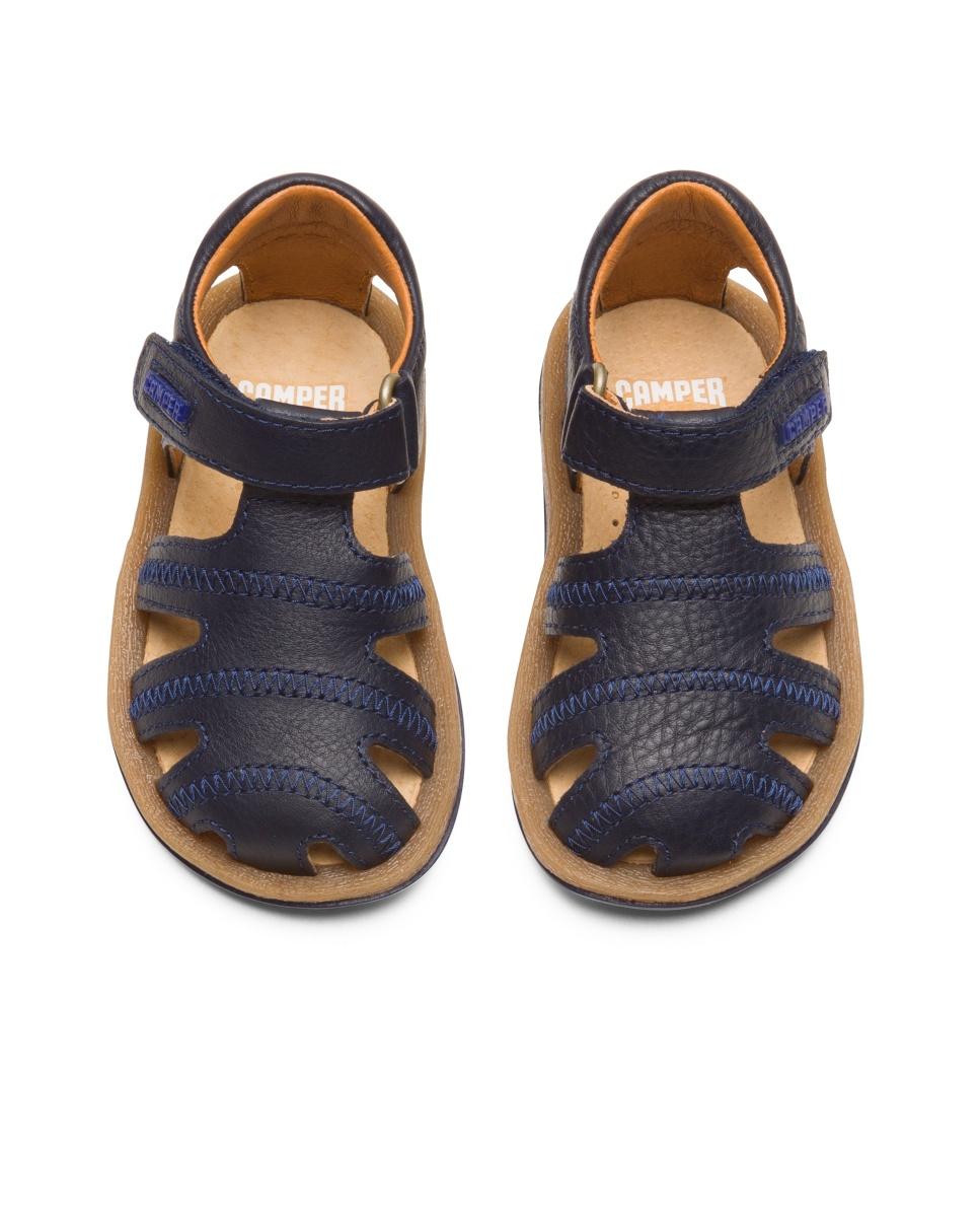 Sandálias fechadas com tira em forma de T para criança. Pele flor e sola de EVA. A coleção Primeiros Passos inclui modelos flexíveis e ao mesmo tempo resistentes para ajudar os mais pequenos quando começam a andar. Sapatos desenhados para que as crianças desfrutem mais das suas primeiras aventuras a caminhar. As nossas sandálias Bicho para menino é ajustável e as suas palmilhas ergonómicas feitas de borracha e casca de arroz recicladas adaptam-se ao pé Camper Azul-marinho-3