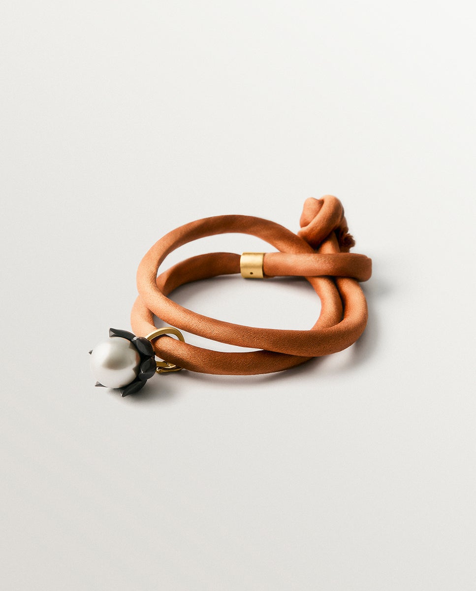 Imagem 0 de Pulseira de Tecido com Charm Flor Banhada em Ouro Amarelo com Acabamento Gumetal e Pérola Cinzenta