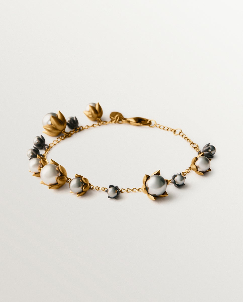 Imagem 0 de Pulseira Bicolor Banhada em Ouro Amarelo e Acabamento Gunmetal com Pérolas Cinzentas e Motivos Florais