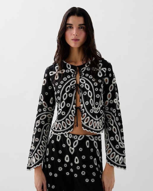 Imagem 0 de Camisa de mulher confecionada em algodão. Estampado bordado em contraste. Mangas compridas levemente à boca de sino. Fecho frontal com laçada. Regular fit.