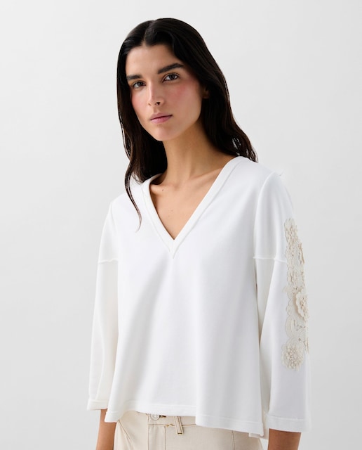 Imagem 0 de Camisola para mulher confecionada principalmente em algodão. Gola em V. Manga comprida. Detalhes bordados nas mangas. Detalhe perfurado nas costas. Regular fit.
