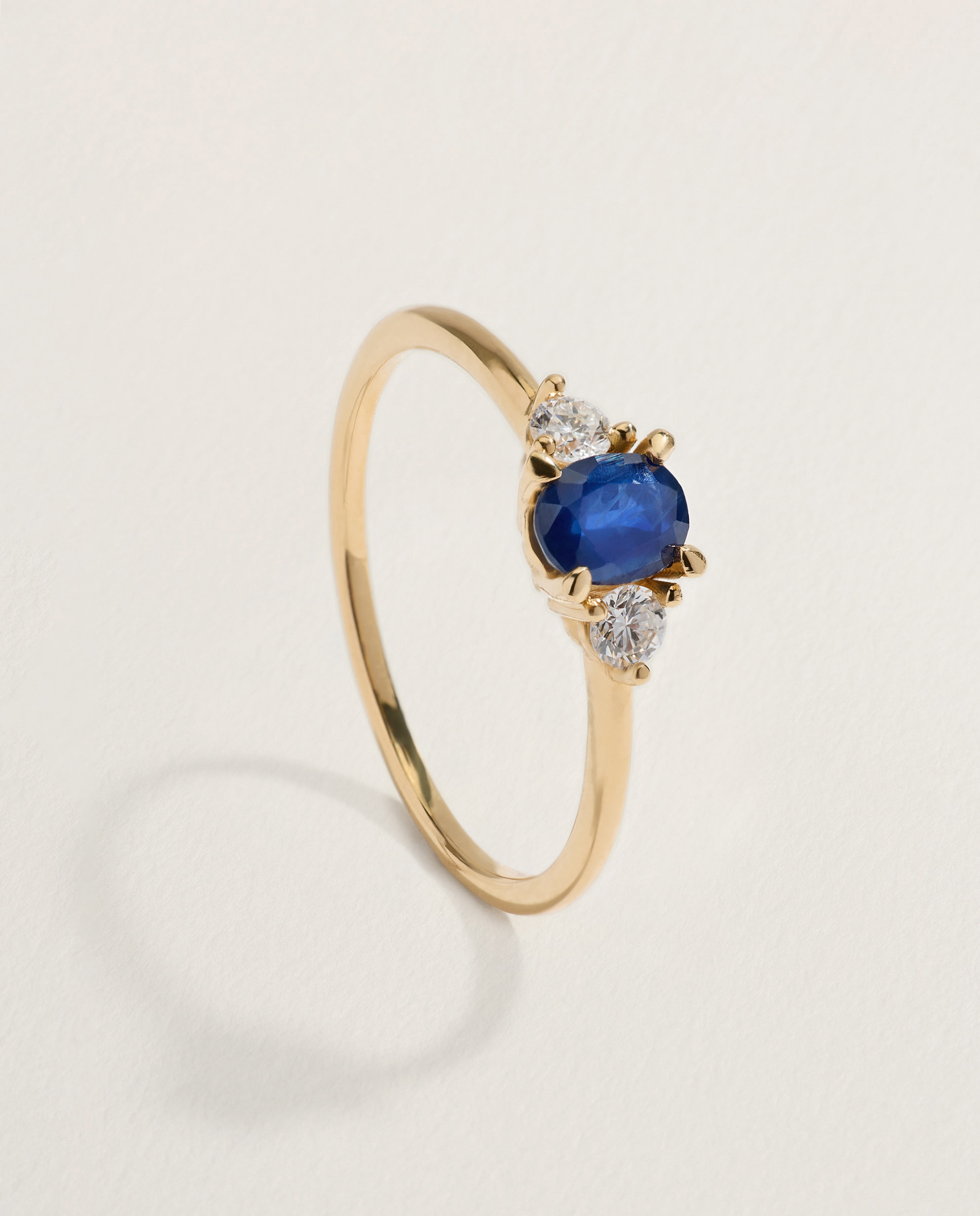 Imagen 0 de Anillo tresillo de oro amarillo de 18K con zafiro en talla oval y 2 diamantes en talla brillante 300 Amarillo
