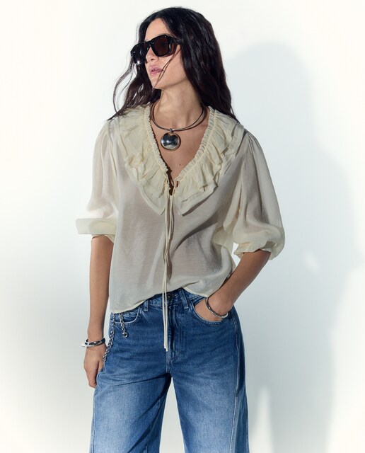 Blusa manga larga con volvante y cuello pico