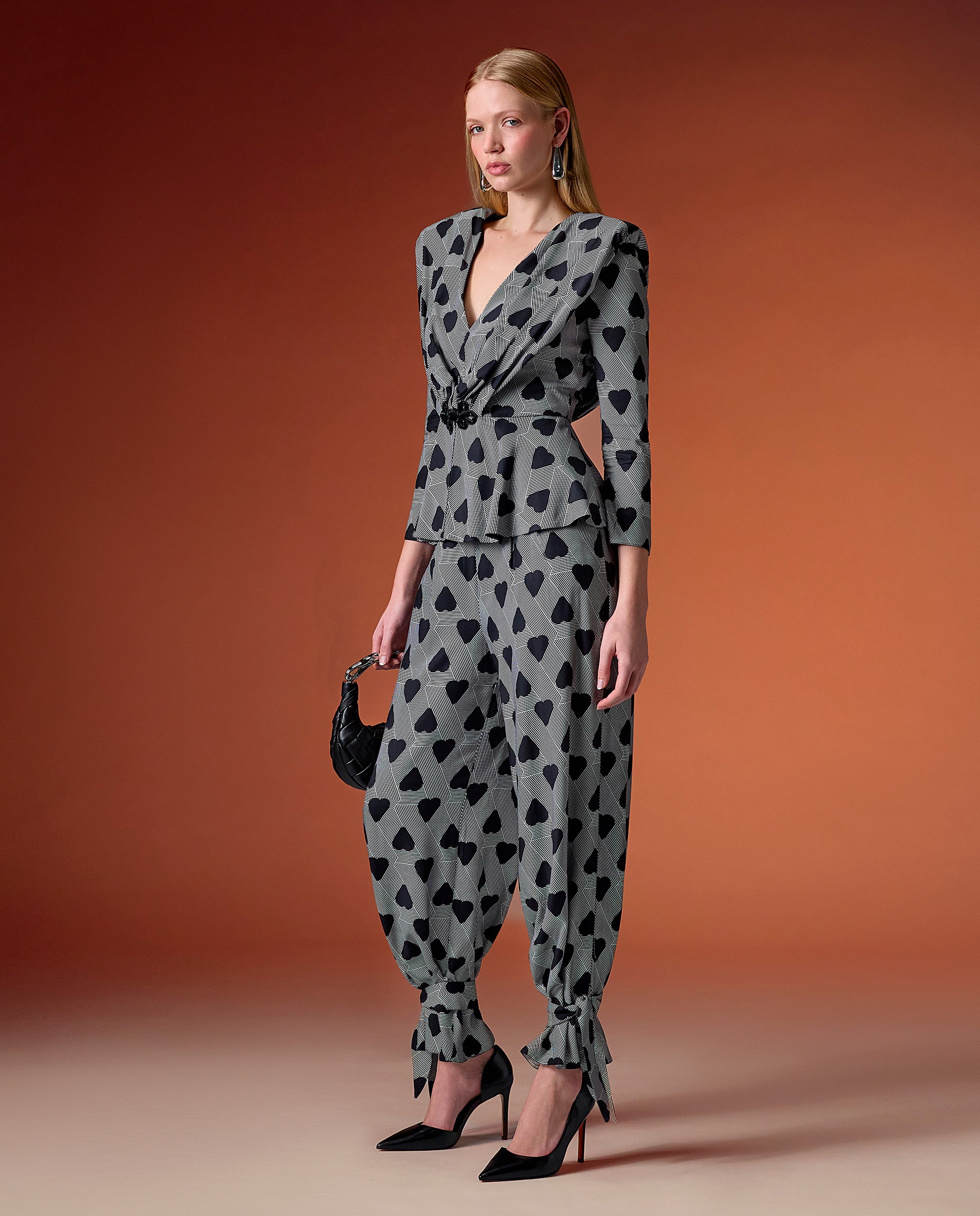 Imagen 0 de Conjunto de dos piezas compuesto por una blusa con escote en v y pantalones con lazos en los tobillos. Gris / Negro
