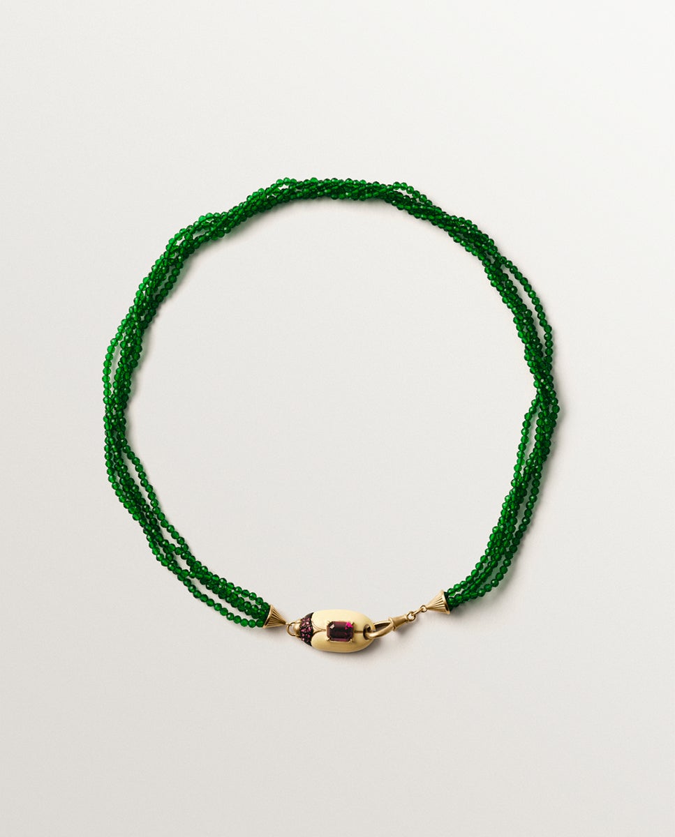 Collar bañado en oro amarillo con cuentas de cristales verdes y forma de escarabajo con cristales rojos