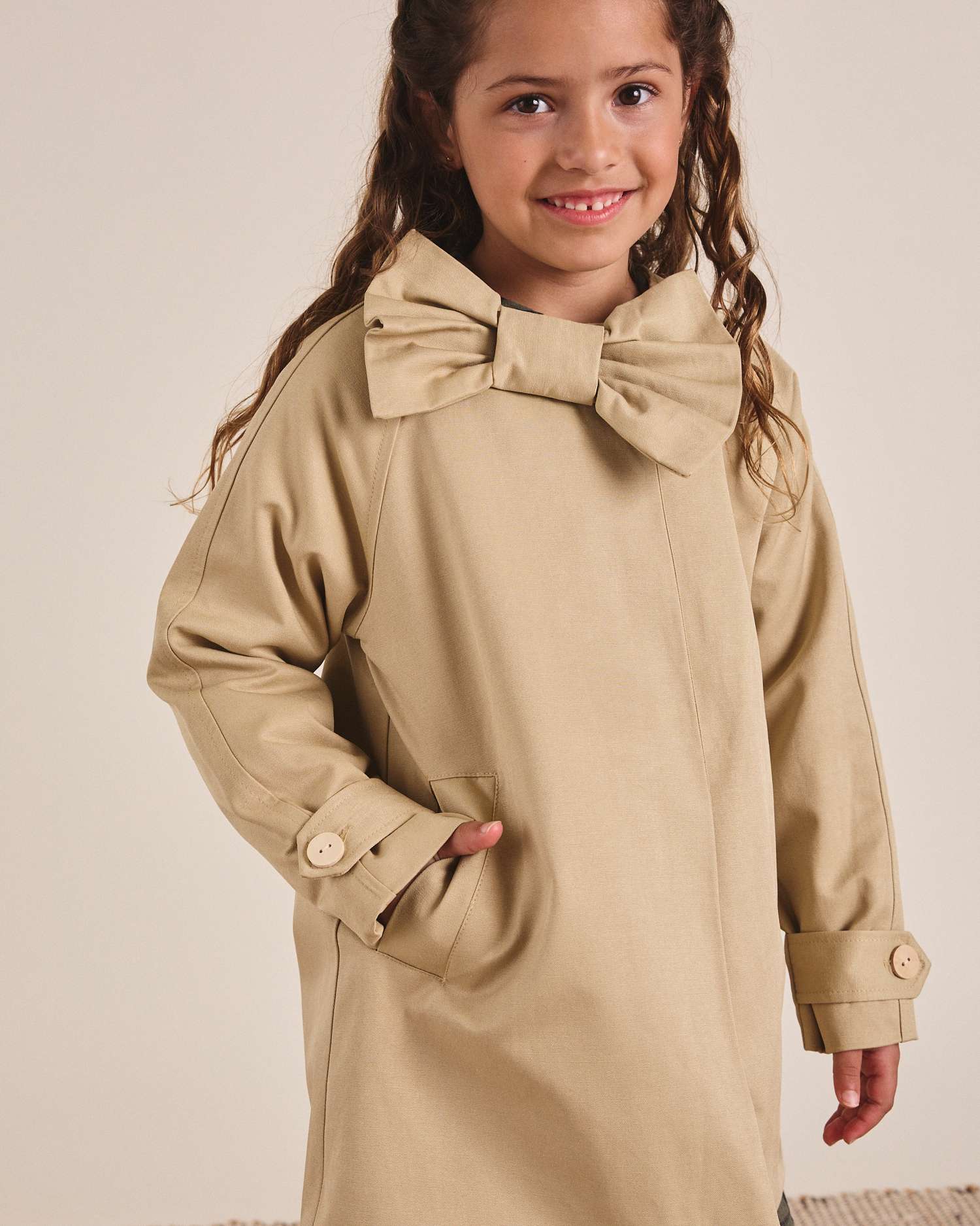 Gabardina de niña en color camel con lazo e interior de guatiné