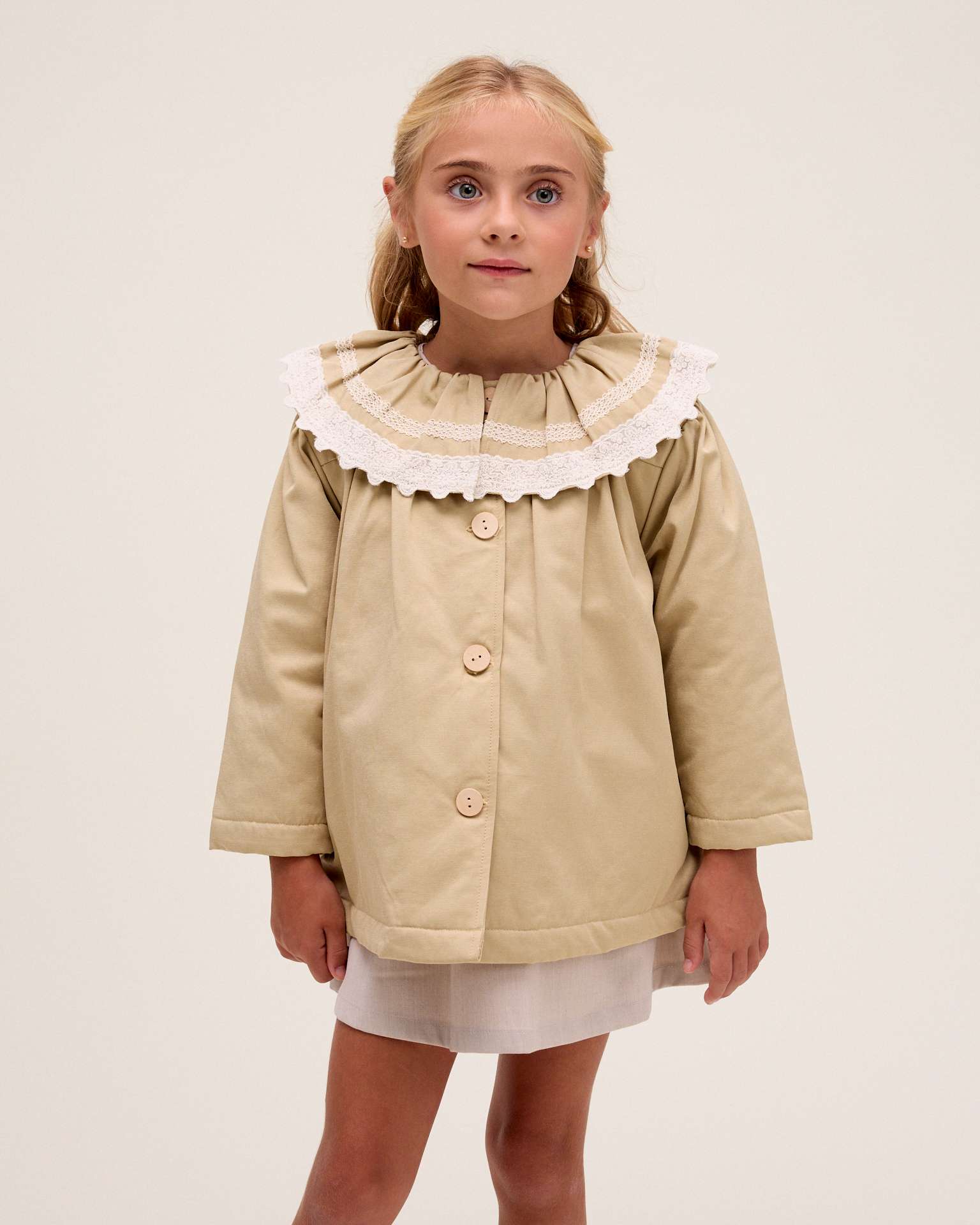 Imagen 0 de Gabardina de niña con volante en el cuello Natural