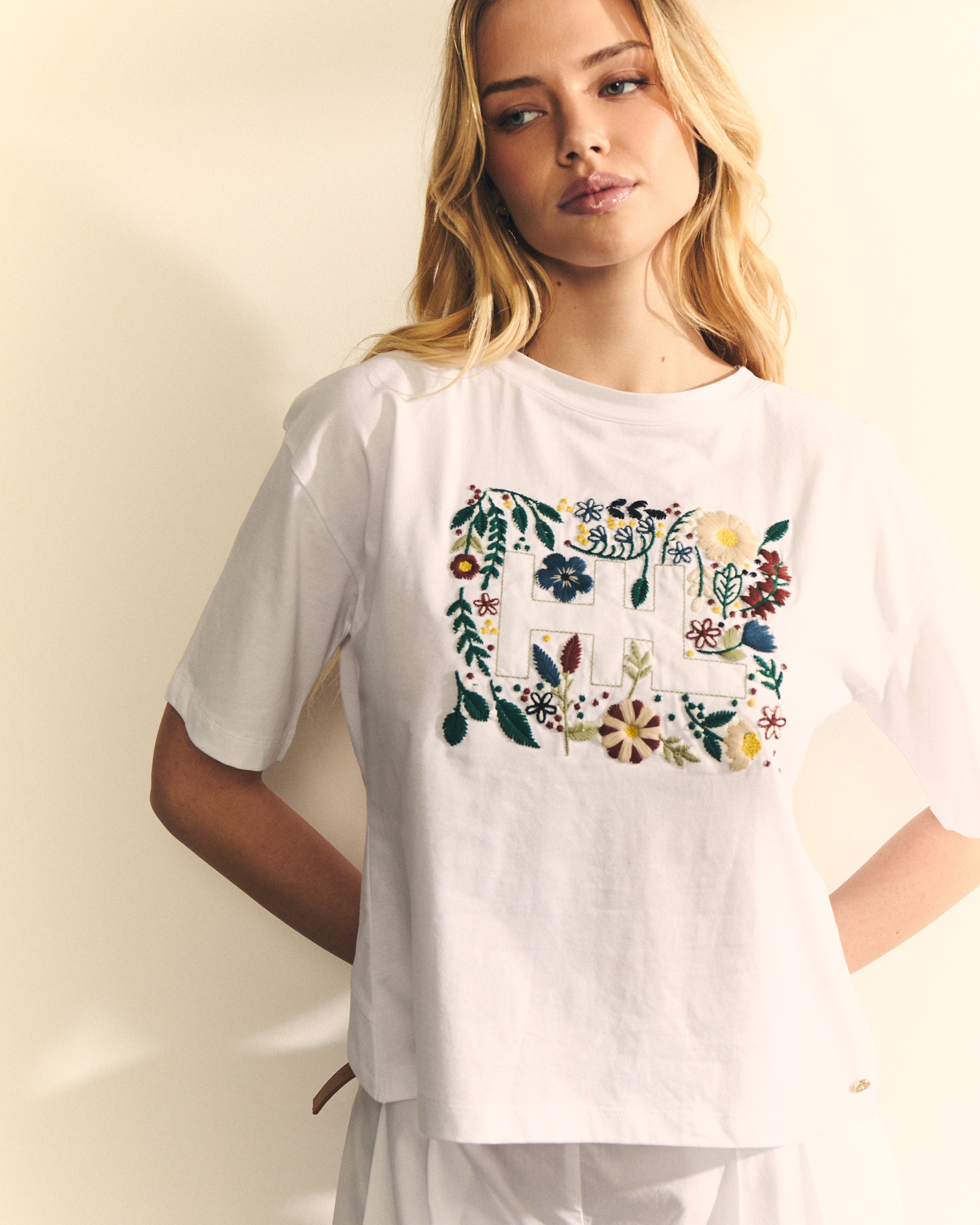 Hannibal Laguna Collection - Camiseta de mujer con espalda con cruce con logo delantero con flores.